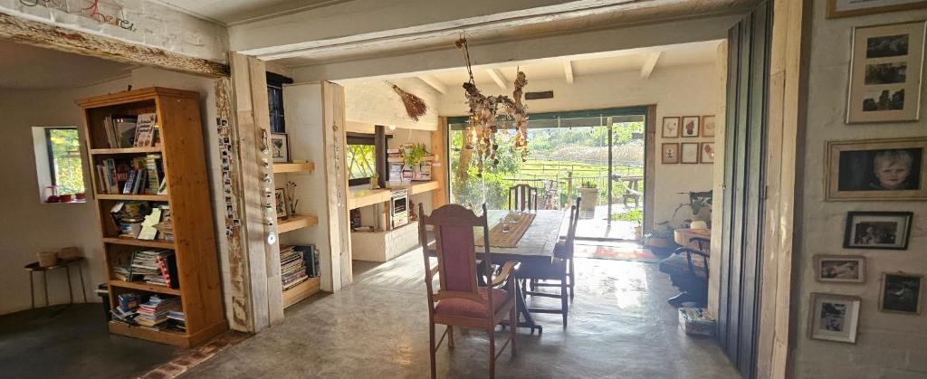 Le Petit Paradis في روبرتسون: غرفة معيشة مع كراسي وغرفة طعام مع نافذة