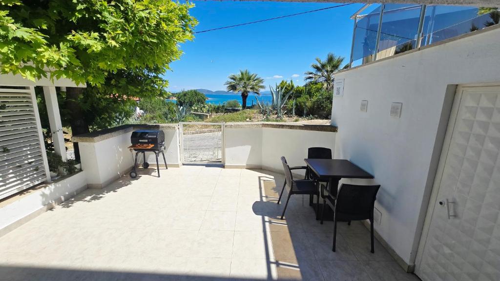 a patio with a table and chairs and a grill at BougainvillaStudio in Cesme