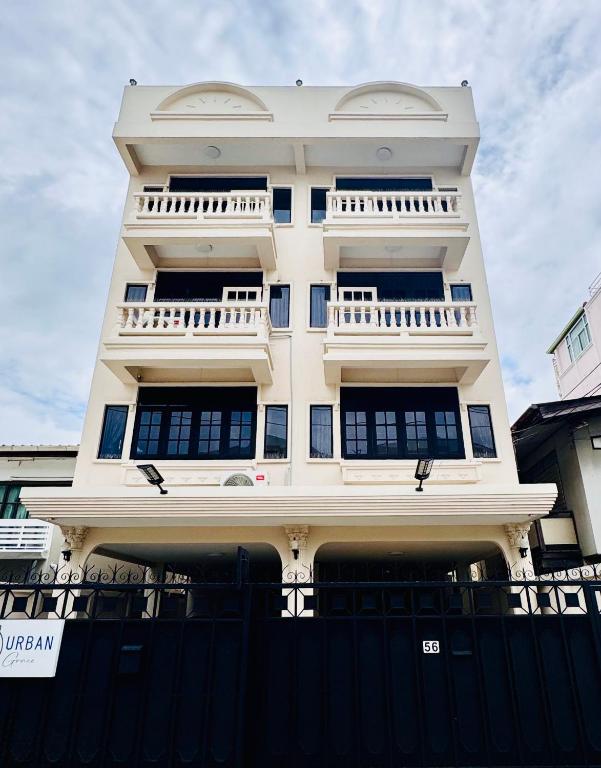 a white building with a fence in front of it at Urban Grace in Bangkok
