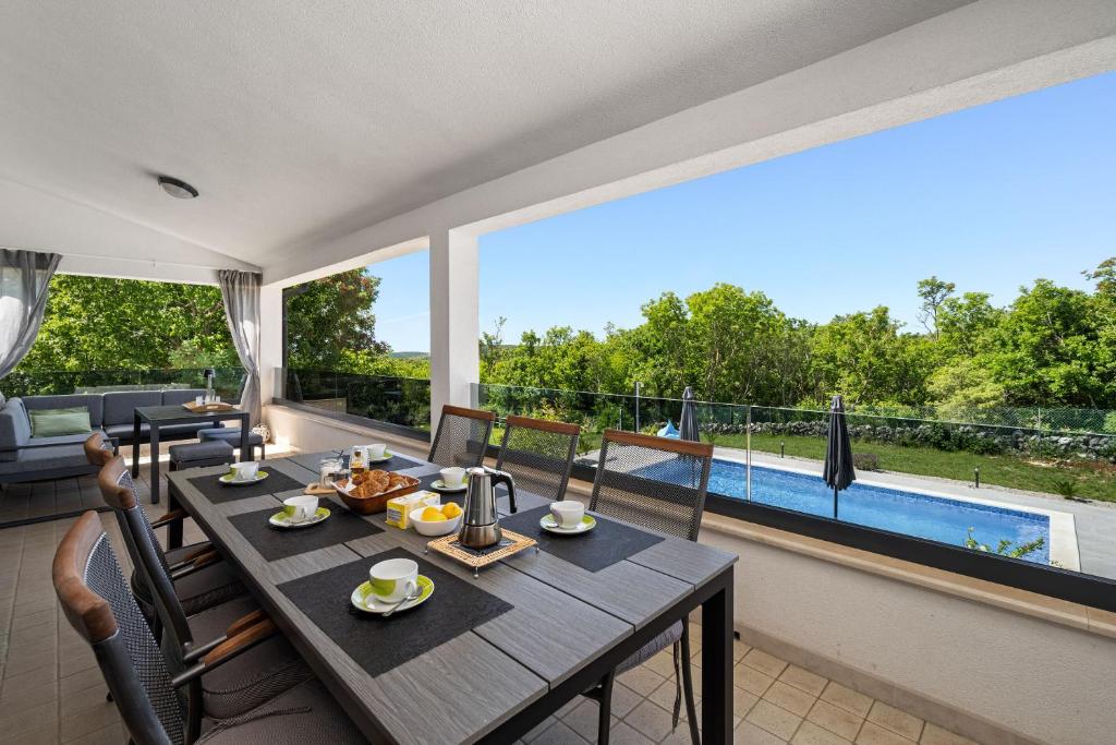 a dining room with a table and a large window at House Trget in Trget