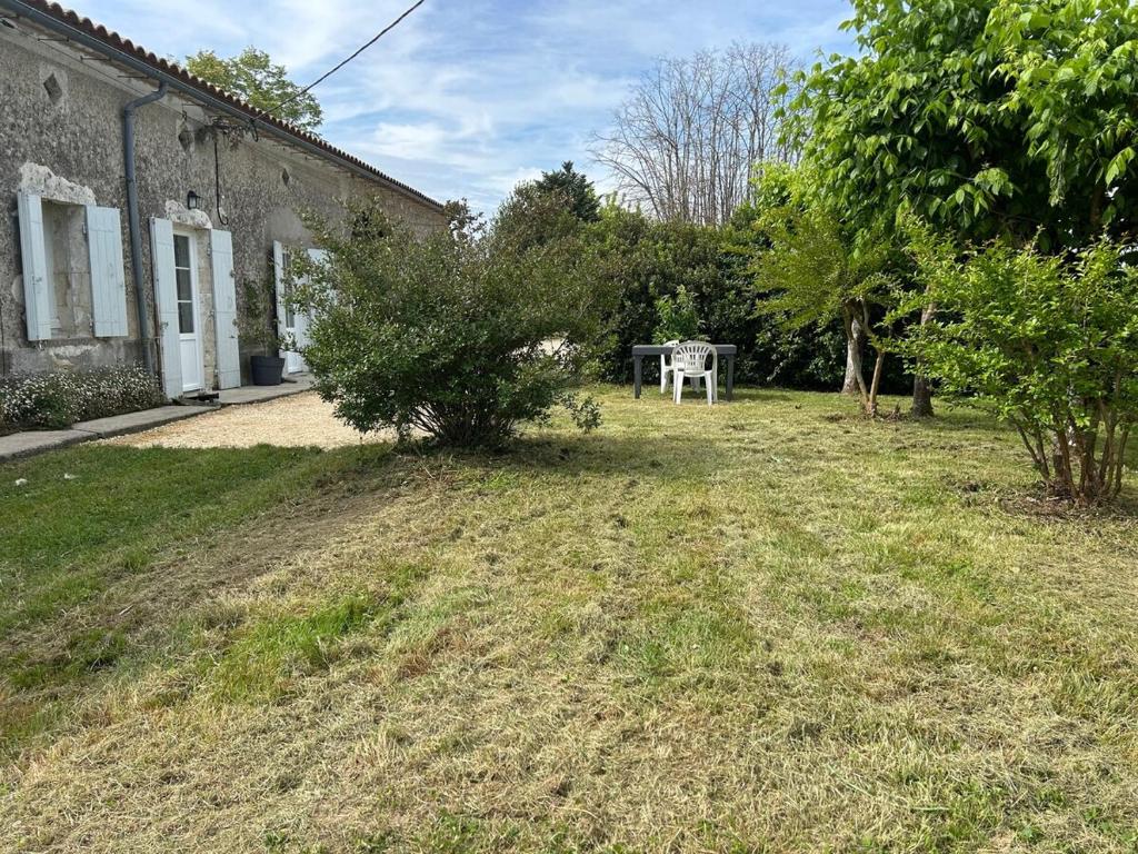 a yard with a table in the back of a building at Gite les grandes vignes in Saint-Sernin