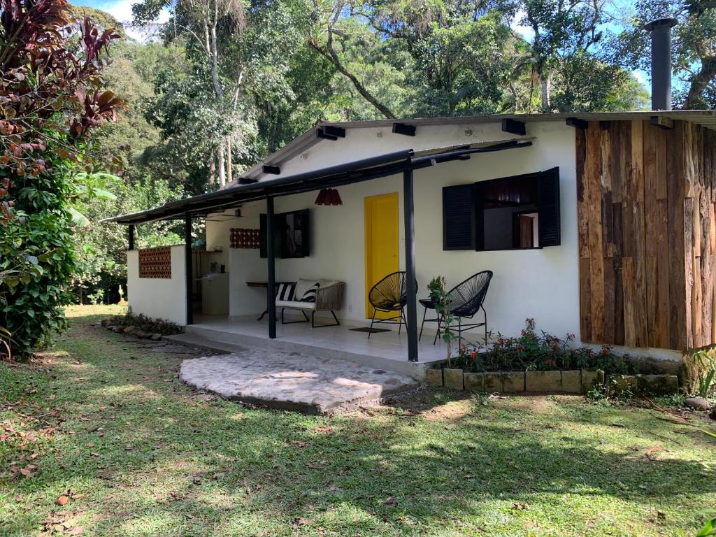 a small white house with a table and chairs at Casa da Dorinha in Teresópolis