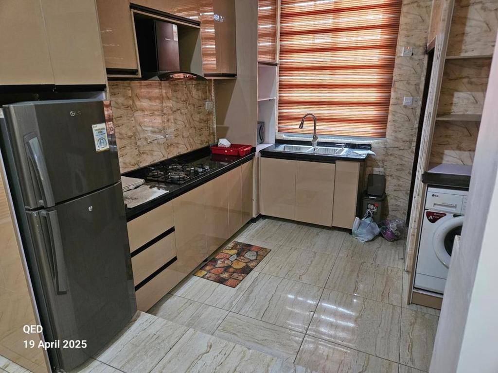 a small kitchen with a sink and a refrigerator at EmeraldSuites Blossom Court Alalubosa GRA in Ibadan