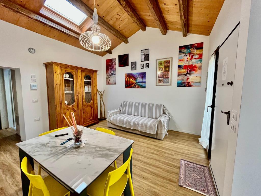 Una sala de estar con una mesa y sillas amarillas. en Levante Flat - 100 m from the beach, en Fano