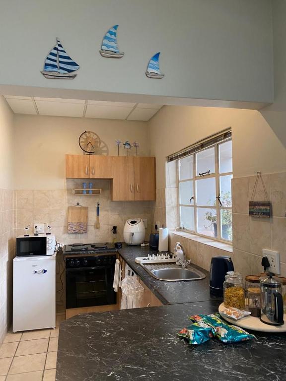 a kitchen with a sink and a white refrigerator at Salt & Cellar - Paarl - Self Catering Apartment in Paarl
