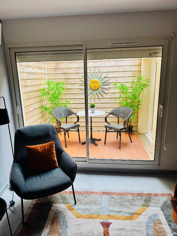 Cette chambre dispose d'une terrasse avec une chaise et une table. dans l'établissement Stylish City Pad - Walk to All, à Bergerac