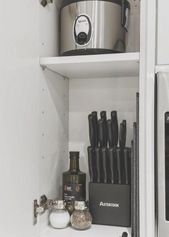 a kitchen shelf with cooking utensils and a pot at The Walk-Up Waikiki Beach in Honolulu