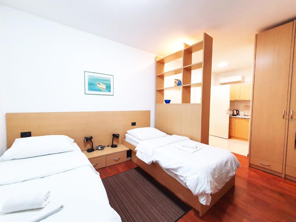 a room with two beds and a closet and a room at Rijeka Budget Rooms in Rijeka