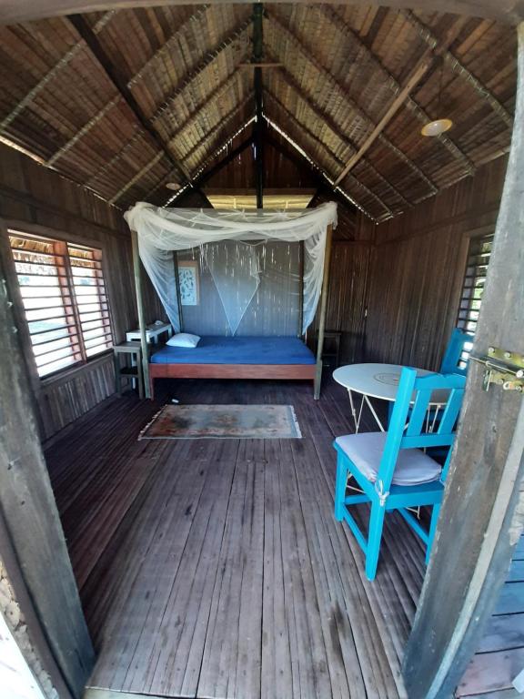 an inside view of a cabin with a table and chairs at La Table d Alexandre Gîte de charme entre mangrove et mer in Hell-Ville
