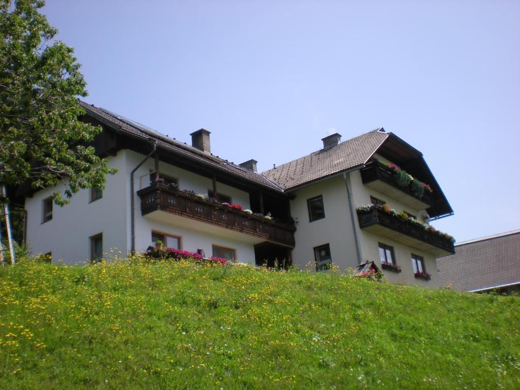 un bâtiment blanc au sommet d'une colline verdoyante dans l'établissement Erlebnishof Schiman, à Kirchbach