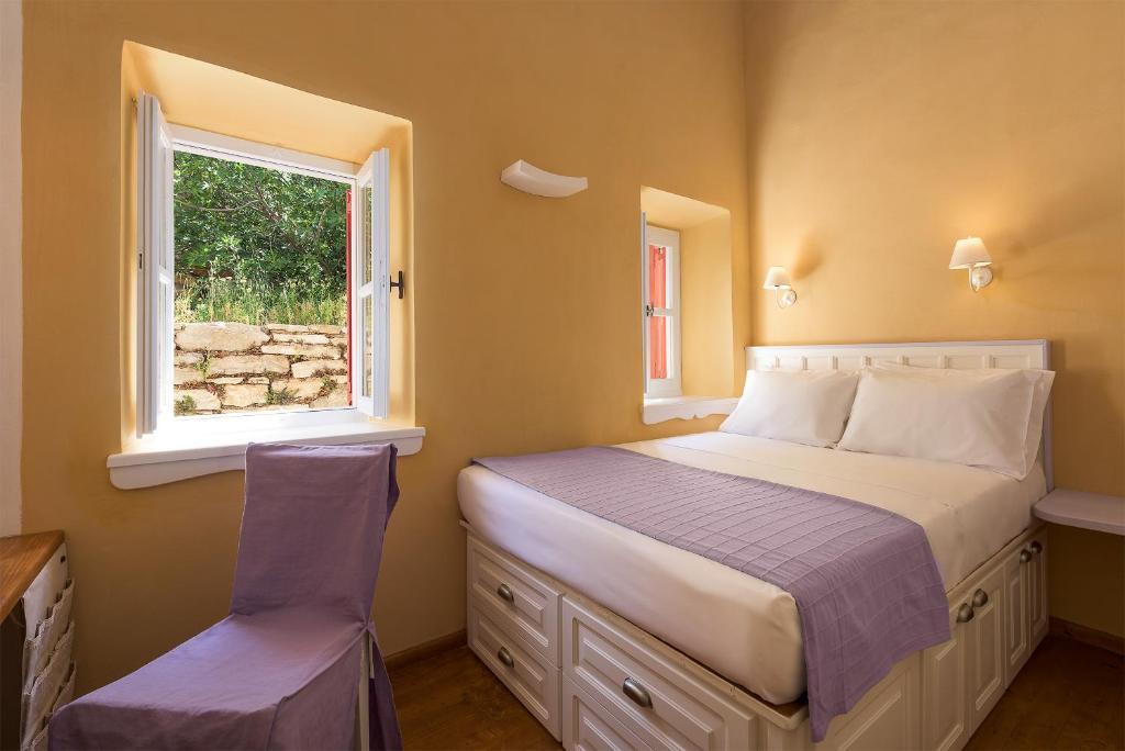 a small bedroom with a bed and a window at Platanos Cottage in Symi