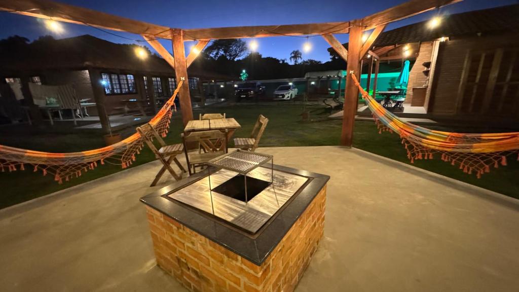 a patio with a fireplace and a table and chairs at Casa Vila Say 04 quartos ar e Piscina Aquecida in São Francisco do Sul