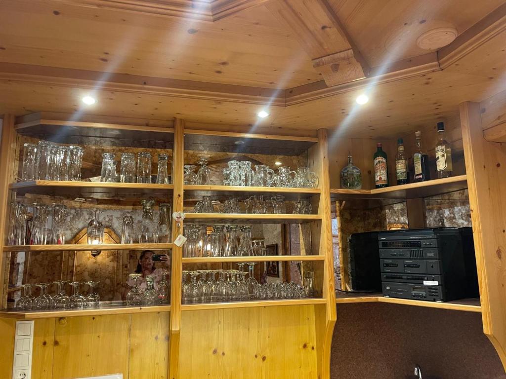 a bar with lots of glasses on shelves at Sportpension Kuen in Tumpen