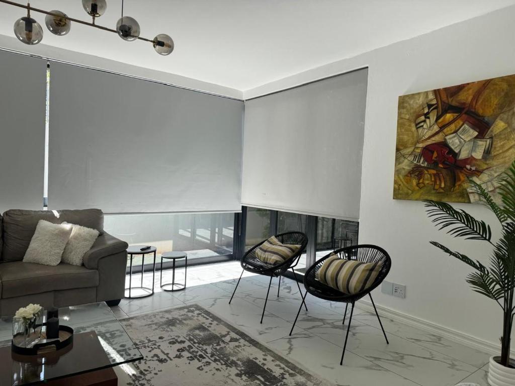 sala de estar con sofá y sillas en Solar - powered Bryanston Home, en Johannesburgo