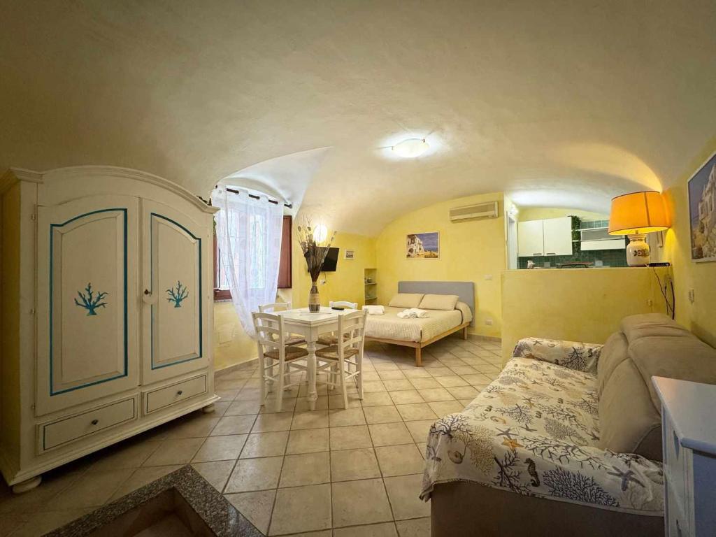 a living room with a bed and a table in a room at La Maddalena Tour Holiday Home - Residenza Alibertini in La Maddalena