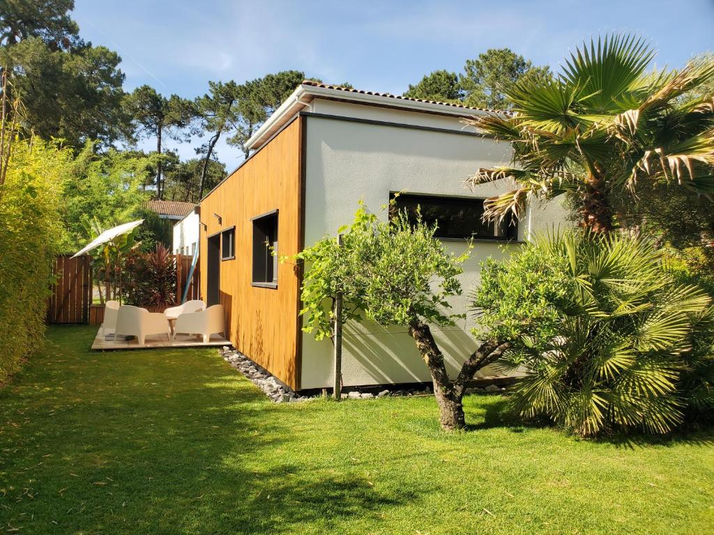 une maison avec un garage et un palmier dans l'établissement La Suite du Jardin - Villa 5 etoiles, à Hossegor