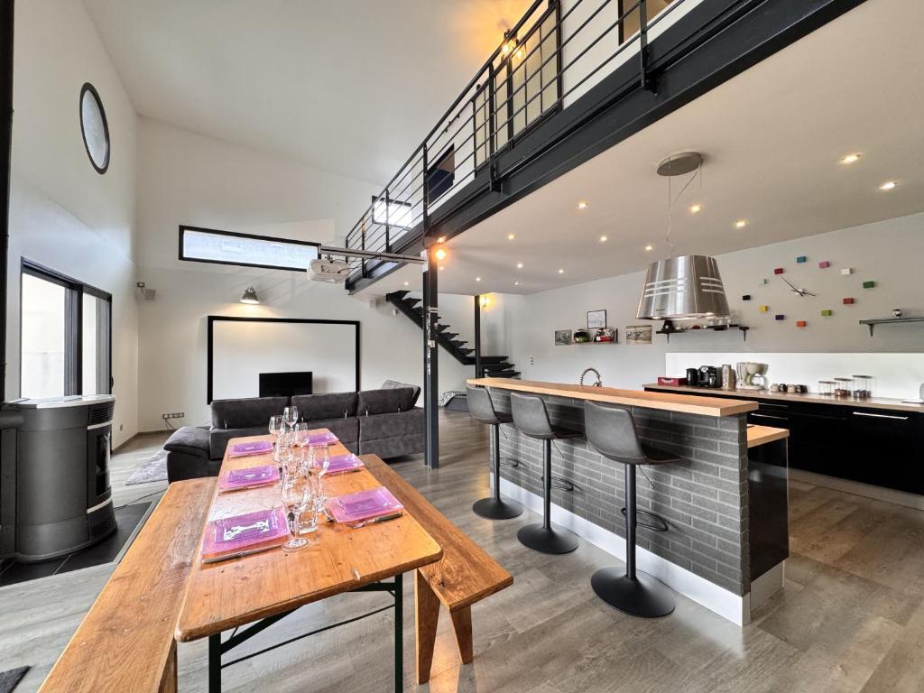 - un salon avec une table et un bar dans l'établissement Le Paddock - Video Projecteur - Jardin - 6 pers, au Mans