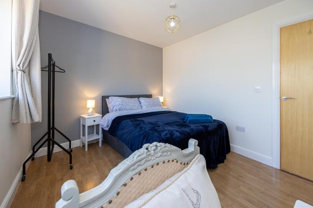 a bedroom with a bed with a blue comforter at Cosy, Central 2 Bed flat parking in Manchester