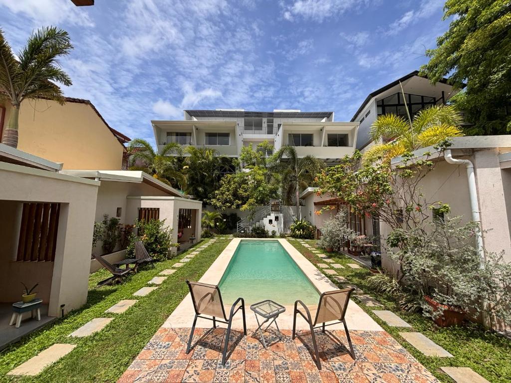 a swimming pool in the backyard of a house at La Ramona Charming Hotel in Tamarindo