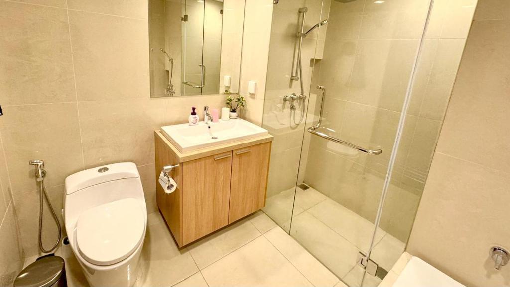 a bathroom with a toilet and a shower and a sink at Best 3 Bedroom Apartment in Mantaak