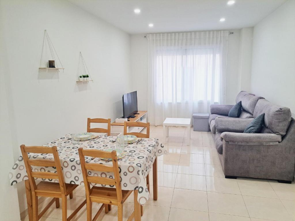 a living room with a table and a couch at 2a Línea de Mar, Playa de Lloret, Centro Histórico in Lloret de Mar