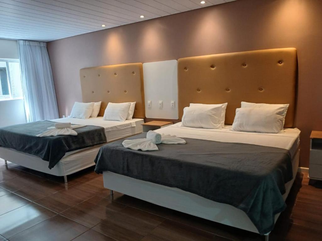 two beds in a hotel room with two beds at Hotel Summer Beach Paripueira in Paripueira