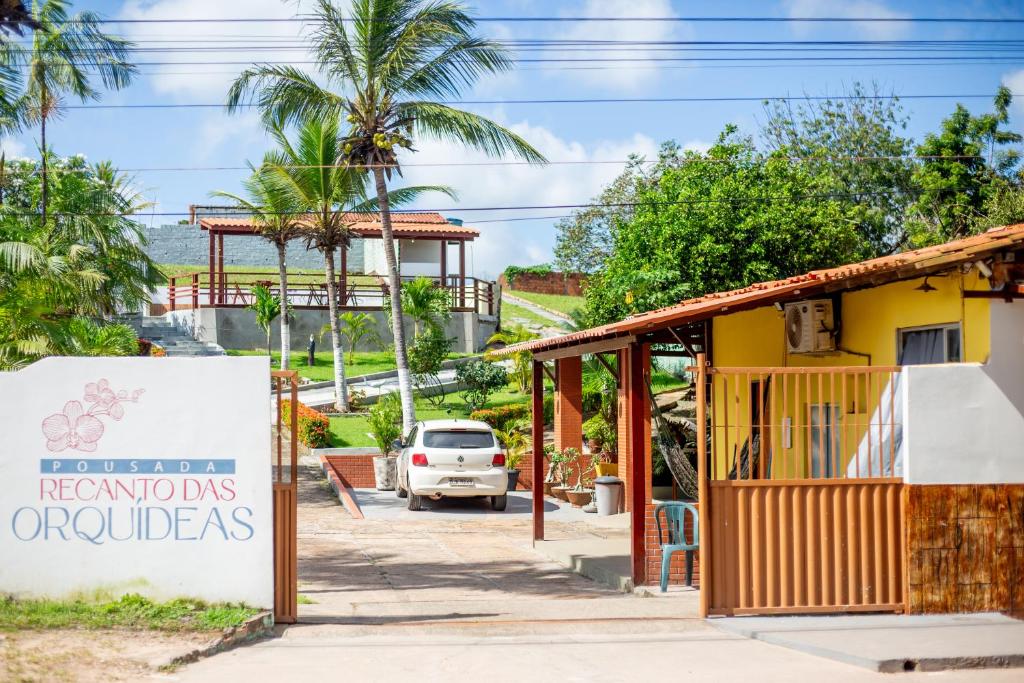 a small yellow building with a sign in front of it at Pousada Recanto das Orquídeas in Barreirinhas