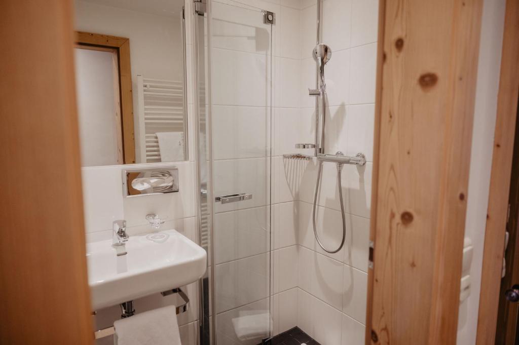 a bathroom with a shower and a sink at Hotel Berghof - St Johann in Salzburg in Sankt Johann im Pongau