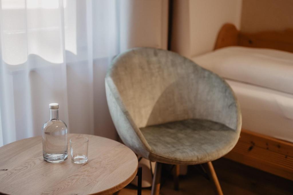 a chair and a table with a bottle on it at Hotel Berghof - St Johann in Salzburg in Sankt Johann im Pongau