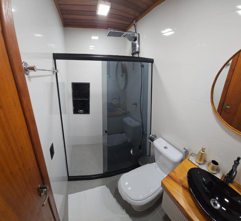 a bathroom with a shower and a toilet and a sink at Chalé na Rampa - Hospedagem no Caravaggio in Santa Teresa