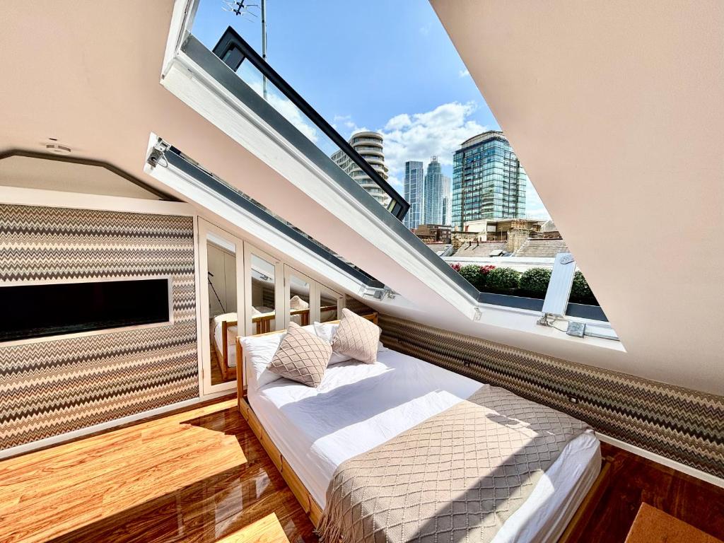 a balcony with a bed and a large window at Elegant and Modern 3-Bedroom Victorian House in Westminster, London in London