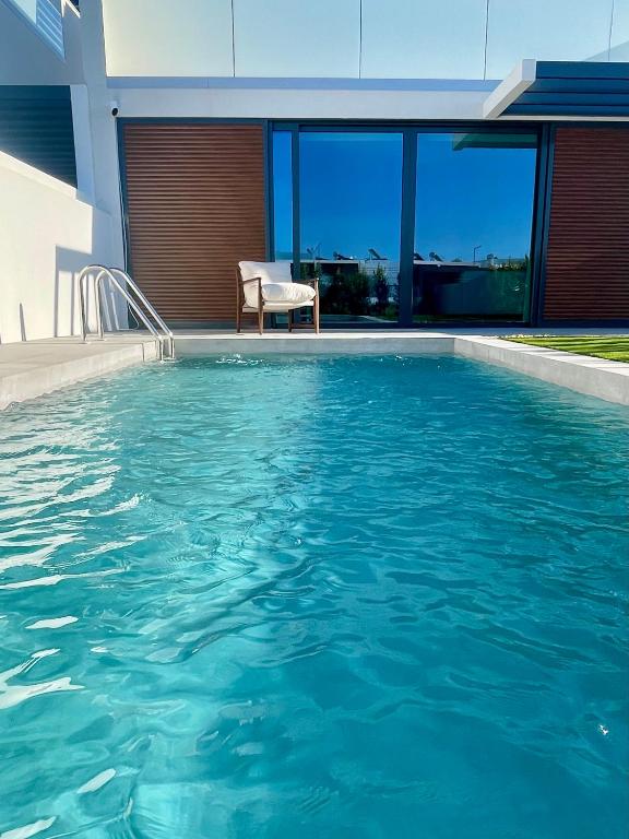 a swimming pool in front of a house at Lux Hiato's Villa in Luz de Tavira