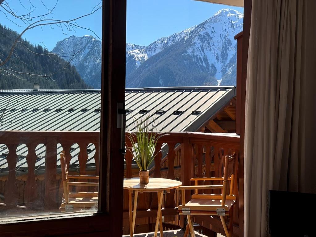 une table et des chaises sur un balcon avec vue sur les montagnes dans l'établissement Geisha - central à 2 min des télécabines, à Champagny-en-Vanoise