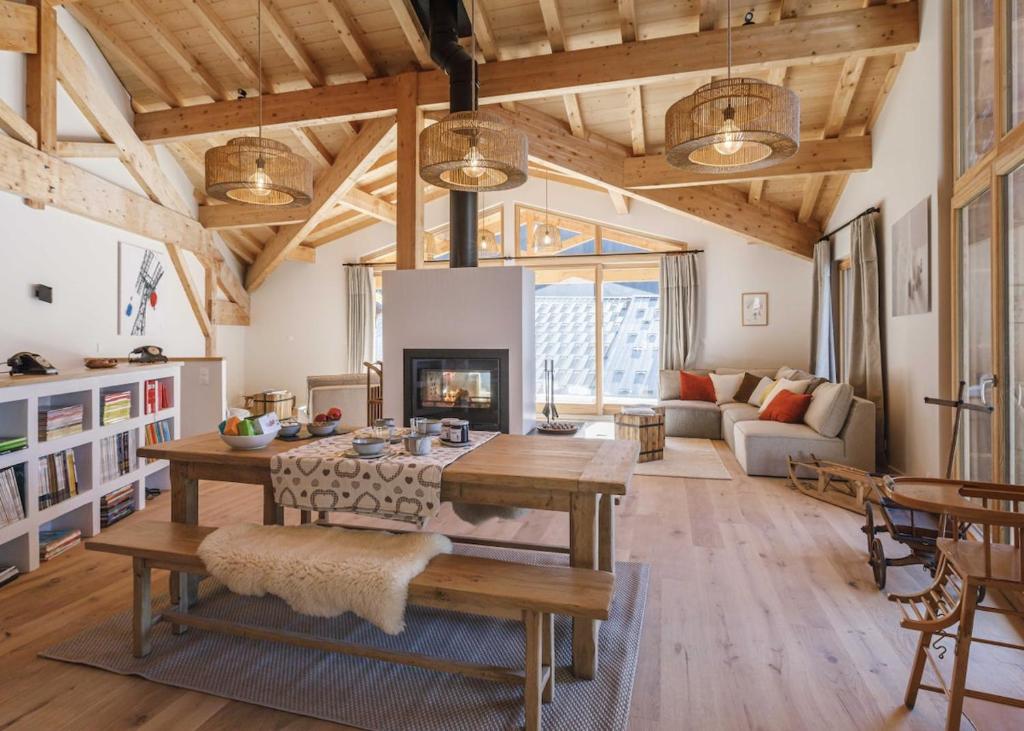 un salon avec une table et une cheminée dans l'établissement Le Malatray Chalet spacieux vue montagne, à Champagny-en-Vanoise