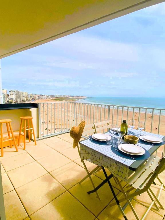 - une table sur un balcon avec vue sur l'océan dans l'établissement LE SUNSET - Face Mer, à Les Sables-dʼOlonne