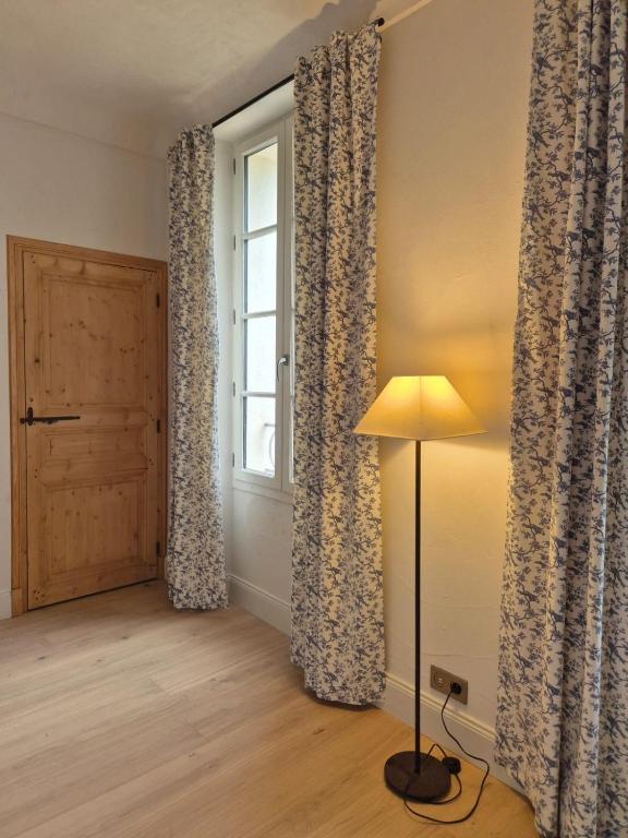 Cette chambre dispose de rideaux, d'une lampe et d'une fenêtre. dans l'établissement Ferme Saint-Georges en Provence, à Le Val