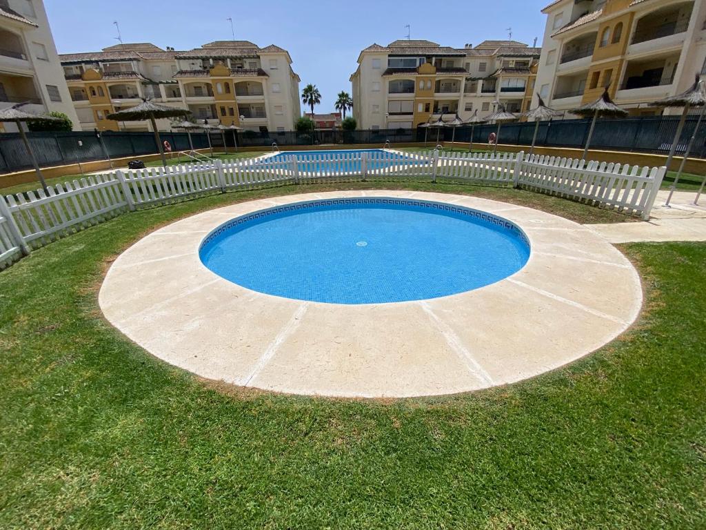 ein kleiner Pool in der Mitte eines Hofes mit Gebäuden in der Unterkunft Apartamento La Laguna in Chipiona