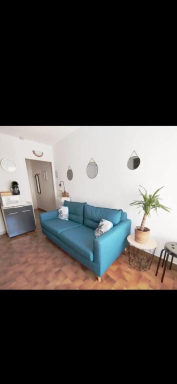 un salon avec un canapé bleu et une table dans l'établissement Appartement Cap D'agde 100 m de la mer, au Cap d'Agde