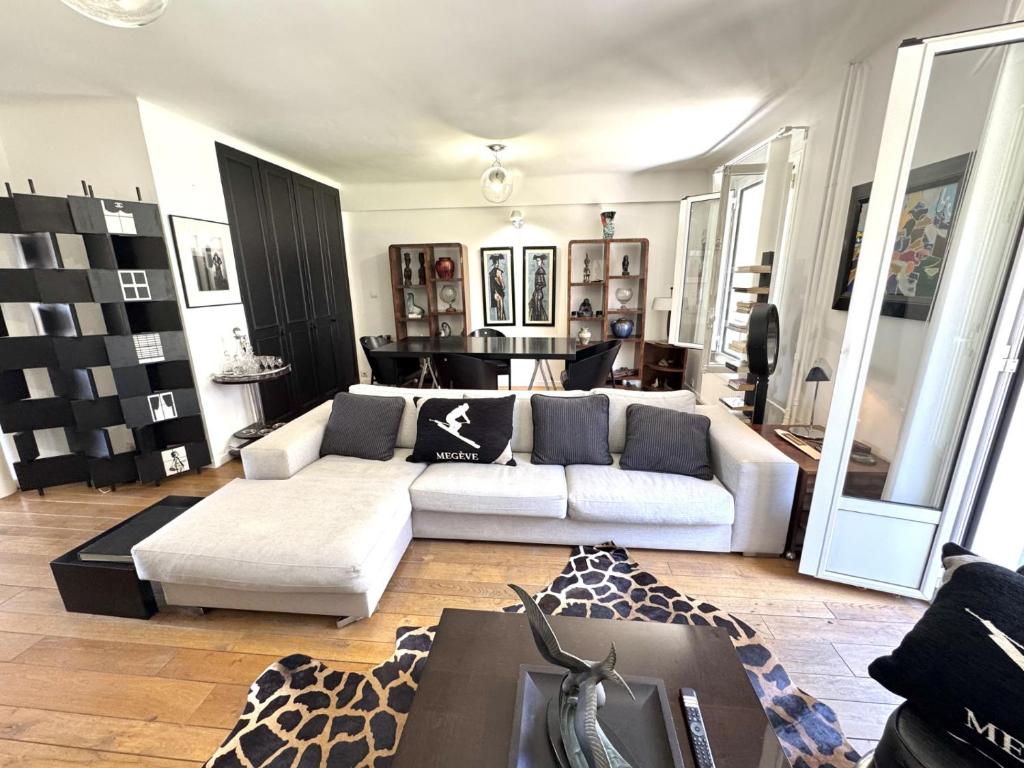 un salon avec un canapé blanc et un tapis girafe dans l'établissement ApartHotel Riviera - Balcon du Serrurier - Old Town - Promenade des Anglais, à Nice