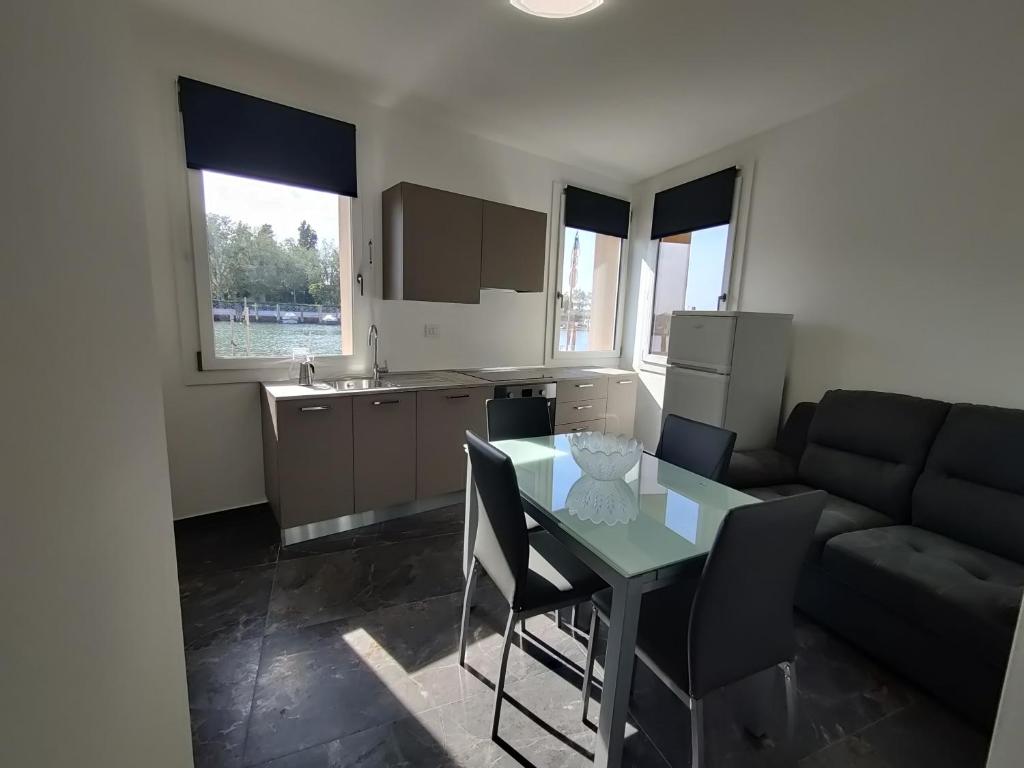 a kitchen and living room with a table and a couch at Ca' Otto Velieri in Sottomarina