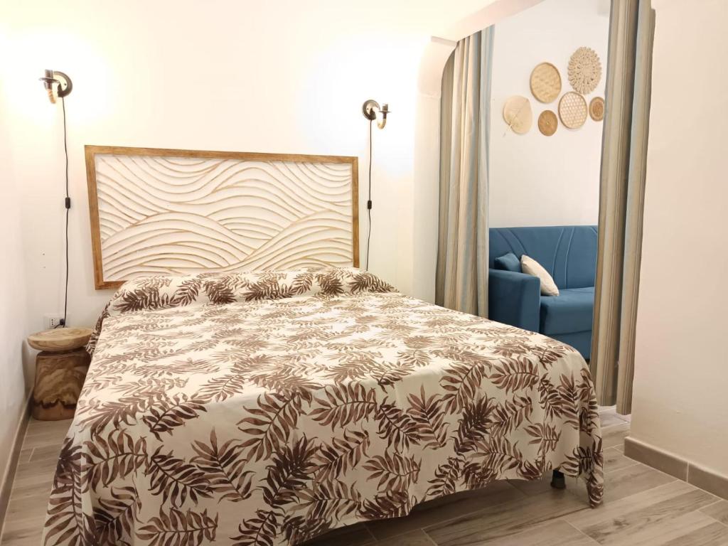 una camera da letto con un letto e un divano blu di Alghero Escape ad Alghero