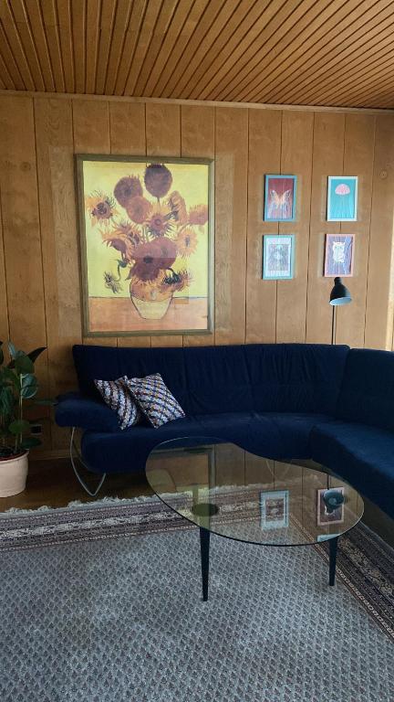 a living room with a blue couch and a glass table at 150 m 5-room Villa 15 min to Düsseldorf in Kaarst