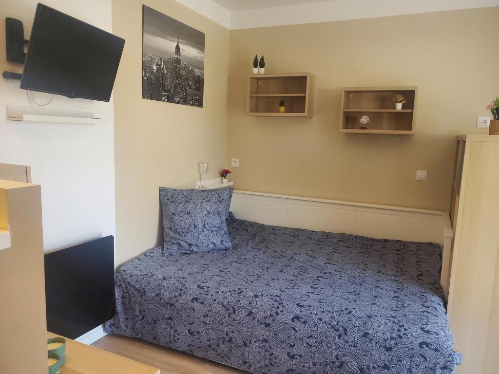 une chambre avec un lit avec une couette bleue dans l'établissement Chaillot 3, à Saintes