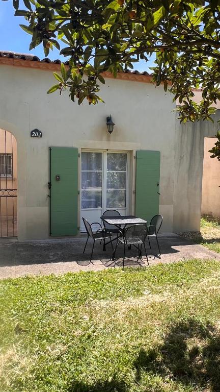 une table et des chaises devant un bâtiment dans l'établissement La villa De Lina 202 -Self Check In, à Gallargues-le-Montueux