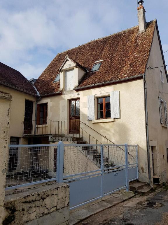 une maison blanche avec une clôture devant dans l'établissement Maison Vigneronne Typique, à Ménétréol-sous-Sancerre