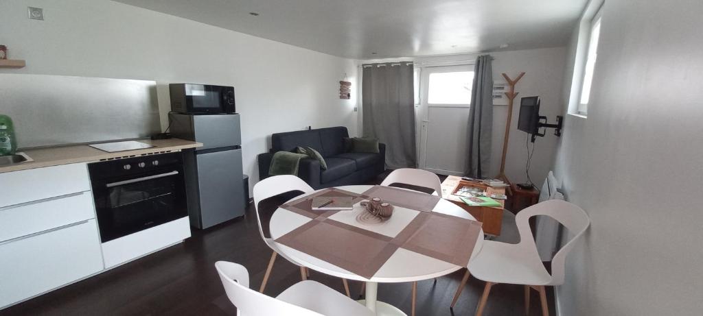 une petite cuisine avec une table et des chaises dans une pièce dans l'établissement Charmant t2 plein pied, à La Celle-sous-Gouzon