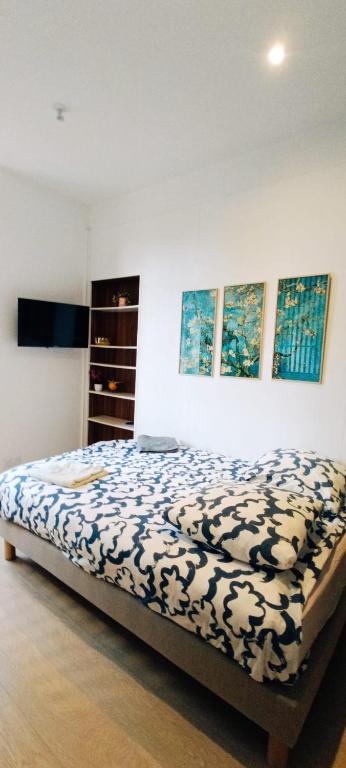 une chambre avec un lit avec une couette bleue et blanche dans l'établissement Suite Shànghǎi Huā - HyperCentre Rennes - 2 personnes - Second Lodge, à Rennes