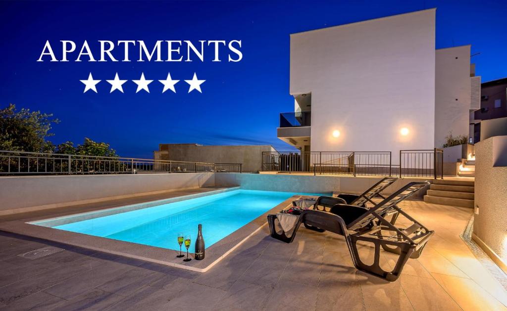 Una piscina con una silla al lado de un edificio. en Apartments 5 Stars Lux XYZ, en Rogoznica