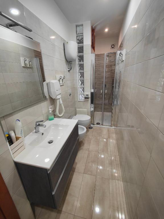 łazienka z umywalką, prysznicem i toaletą w obiekcie B&B Maestra Giovanna w mieście Pompeje