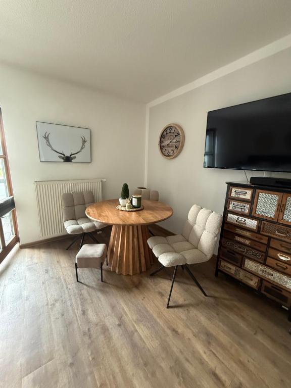 un salon avec une table, des chaises et une télévision dans l'établissement LITTLE COTTAGE - Kleine Wohlfühloase, à Obernzell